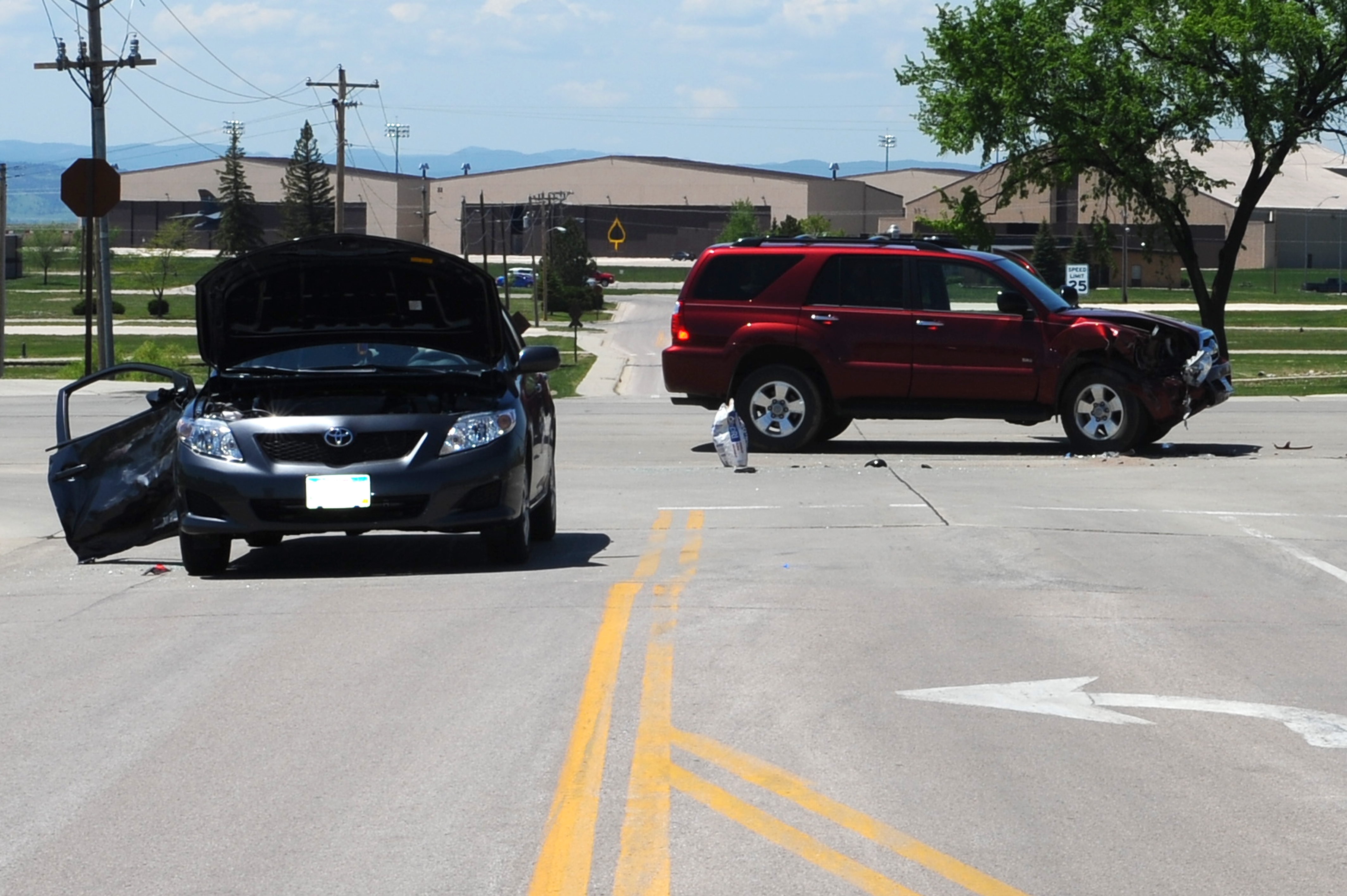 Two vehicles collided at a busy intersection, with visible damage and emergency response attending the scene
