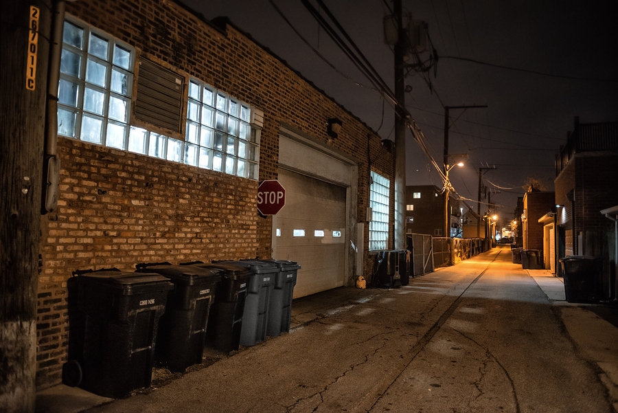 Dark, eerie industrial urban setting with abandoned buildings, dim lighting, and a gritty, desolate atmosphere