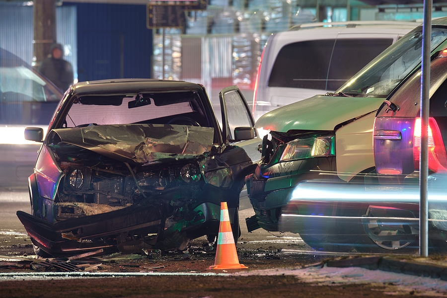 Two cars involved in a road collision accident with visible damage on a city street
