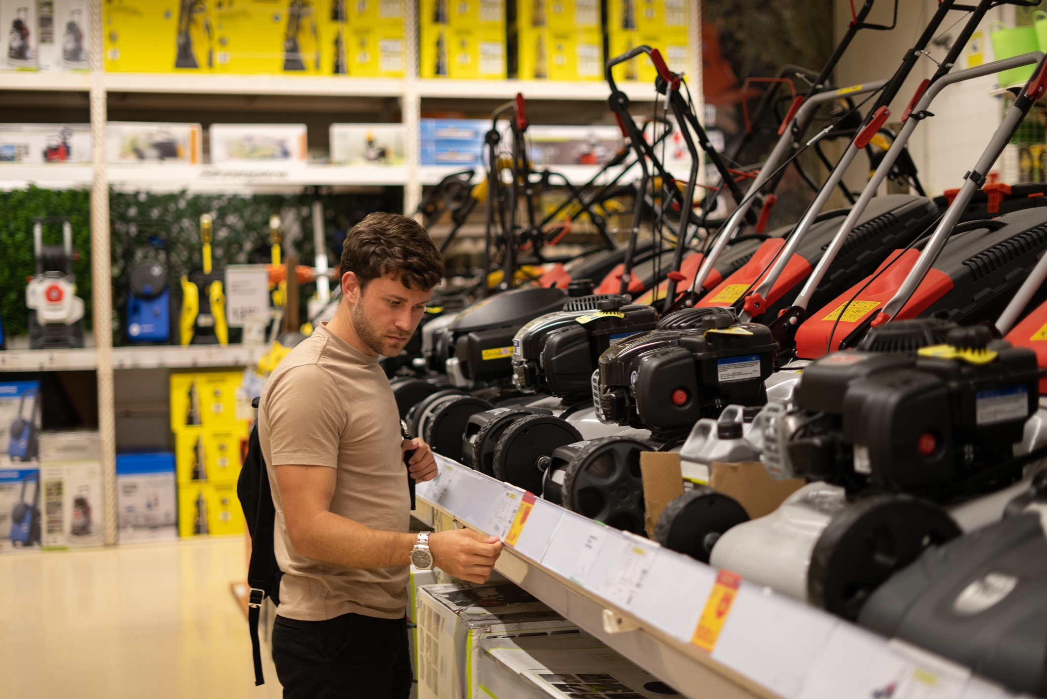 Customer browsing electric gardening tools in a retail store aisle