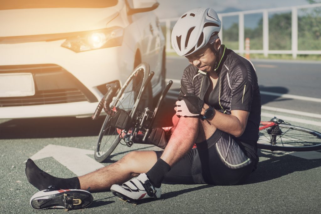 Car collided with a bicycle, leaving the cyclist injured on the road after a traffic accident