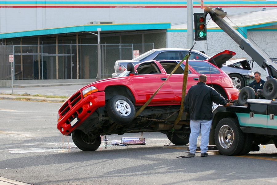 Person documenting a car accident and filling out an insurance claim form for compensation