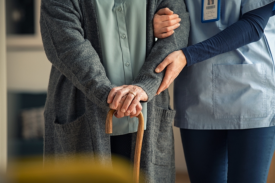 Close-up of caregiver gently holding a patient’s hands, showing compassion, support, and medical care