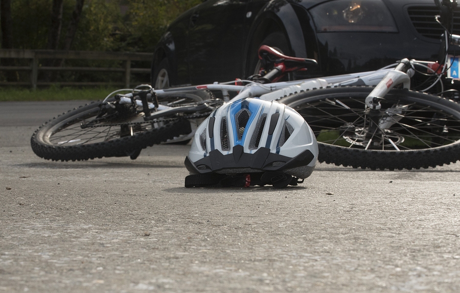 Bicycle accident involving a cyclist on the road after collision with a vehicle, resulting in injuries