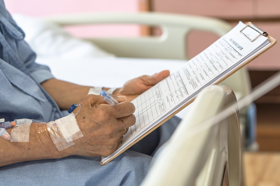 Person filling out a health insurance claim form with medical documents and paperwork